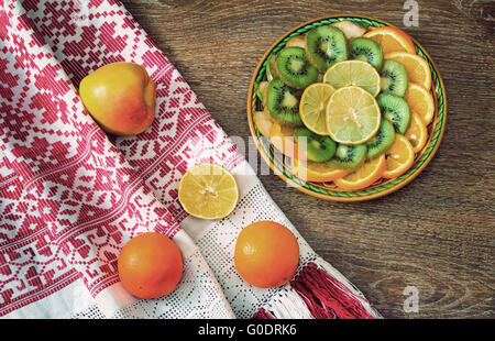 Frutti e bellissimo vecchio asciugamano sul tavolo surfac Foto Stock