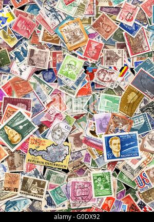 Centinaia di francobolli provenienti da molti paesi diversi Foto Stock