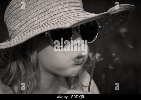 Ritratto di una bambina con un dente di leone nero w Foto Stock