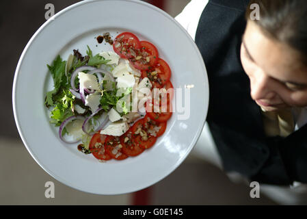 Cameriera portando pasto sano Foto Stock