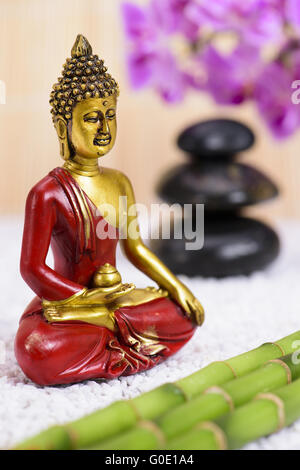 La figura del Buddha in giardino zen con pietre impilate Foto Stock