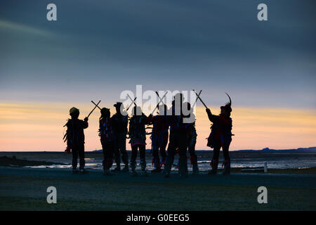 'Rag Bag Morris' che segna il giorno di Maggio sulla strada rialzata per l'Isola Santa di Lindisfarne, Northumberland. Ogni anno ballano all'alba il giorno di maggio in un luogo diverso nel nord del Northumberland o nei confini scozzesi. Foto Stock