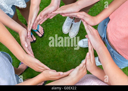 Molte armi di bambini con le mani facendo cerchio Foto Stock