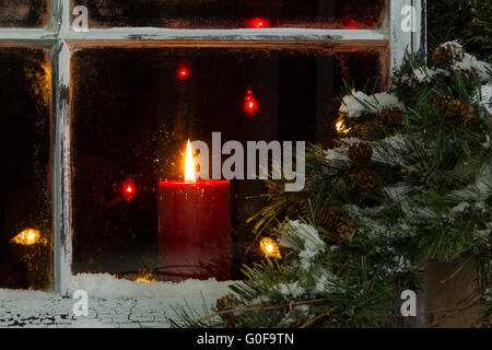 Incandescente christmas candle in smerigliato finestra home Foto Stock
