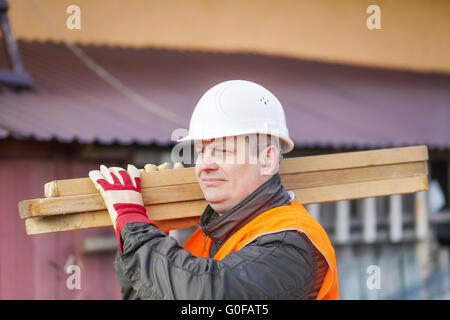 Falegname con schede sulle loro spalle Foto Stock