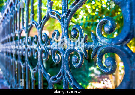 Il design classico nero ferro battuto cancello in un bellissimo giardino verde Foto Stock