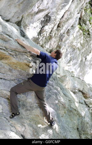 Uomo si arrampica sulla parete di roccia Foto Stock