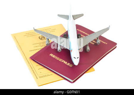 Toy piano sul passaporto e carta di vaccinazione Foto Stock