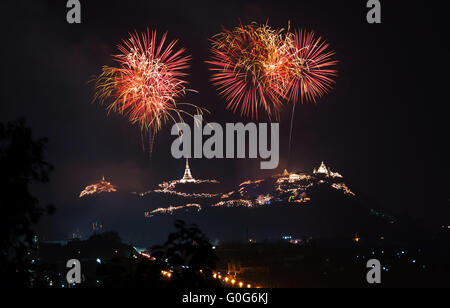 Il Buddismo Pagoda sui picchi di montagna con illuminazione decorativa e di sera i fuochi d'artificio di notte per la celebrazione annuale. Thailandia. Foto Stock