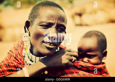 Maasai baby portato da sua madre in Tanzania, Africa Foto Stock