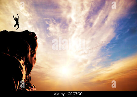 Uomo felice salti di gioia sulla cima della montagna Foto Stock
