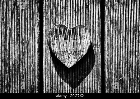 Un annata di legno cuore su grunge tavole di legno. Simbolo dell amore Foto Stock