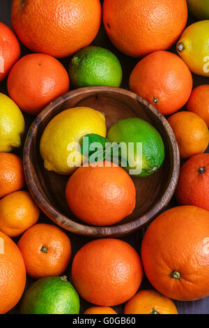 Mound gli agrumi in piatto di legno macro Foto Stock