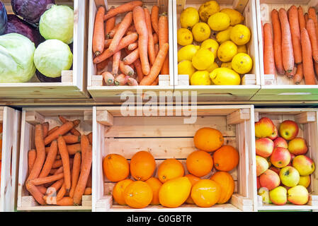 Frutta e verdura in cassette di legno per la vendita su un mercato Foto Stock