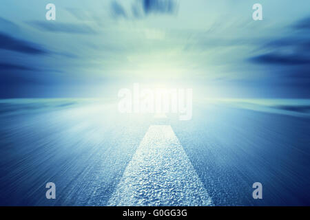 Vuoto lungo strada asfaltata verso la luce. Motion Foto Stock