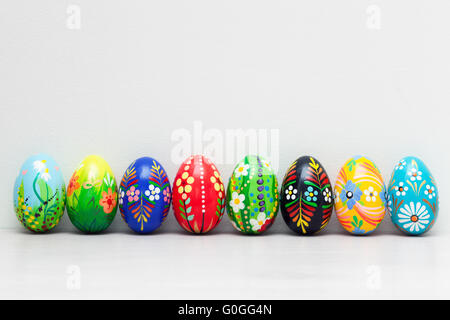 Dipinte a mano e le uova di Pasqua di raccolta su bianco parete rustico. Floral Foto Stock