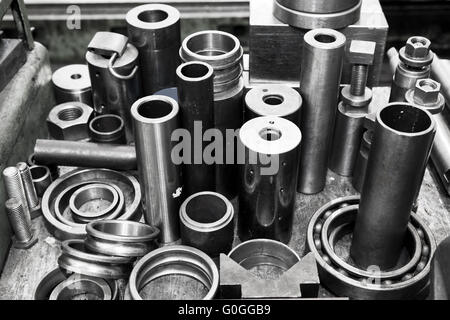 Cilindri in acciaio, pistoni e strumenti in officina. Tema dell'industria. Foto Stock