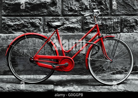 Retro Vintage bici rosso su bianco e nero parete. Foto Stock