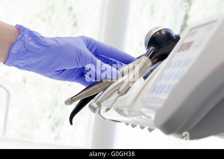 Dentista picking strumenti odontoiatrici in studio dentistico. Odontoiatria Foto Stock