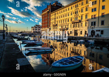 Sun va giù e vernici di colori sulla parete degli edifici di Trieste Foto Stock