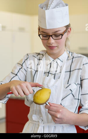 Felice teenage-cuocere la pelatura di patate Foto Stock