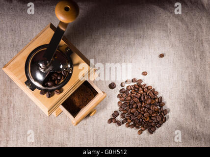 Vista dall'alto in basso sulla piazza di legno a forma di macinino da caffè, i giardini e la piccola pila di fagioli su tela Foto Stock