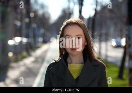 Bella donna asiatica con maglione giallo e rivestimento di oliva camminando sulla strada Foto Stock