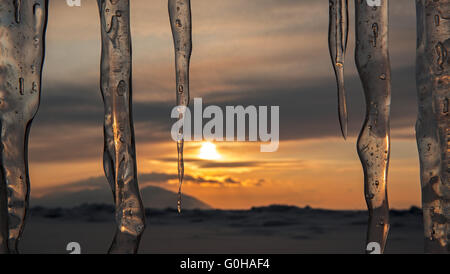 Regolazione del sole viene riflessa in ghiaccioli. Foto Stock