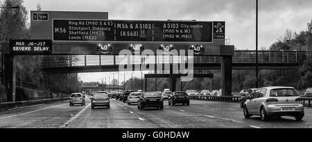 Traffico Autostradale in coda al di sotto di overhead gantry lampeggia con segni di matrice 40mph e severo avvertimento di ritardo Foto Stock