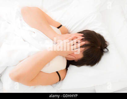 Brunette donna nel letto Foto Stock