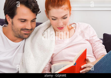 Dolce matura in appoggio sul lettino durante la lettura di un libro Foto Stock