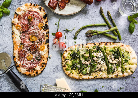La Pizza per la condivisione, dal di sopra su sfondo di ardesia, piatto ingredienti dei laici Foto Stock