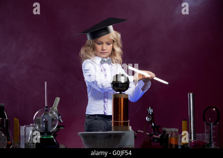 Carino piccolo scienziato che pongono nel laboratorio di fisica Foto Stock