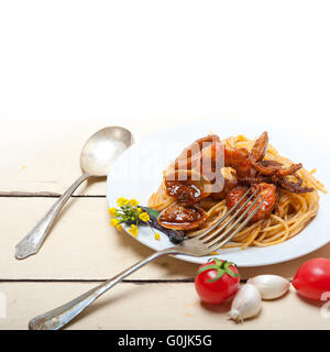 Pesce italiano gli spaghetti in salsa di pomodoro rosso su bianco tavola in legno rustico Foto Stock