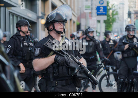 Seattle, WA, Stati Uniti d'America. 1 Maggio,2016. I dirigenti non letale folla dispositivo di dispersione di guardare oltre i manifestanti marciano in downtown. Maria S./Alamy Live news Foto Stock