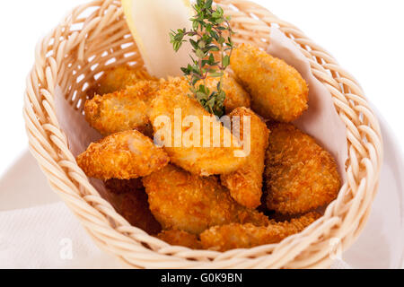 Impanati pepite di pollo in un cestello Foto Stock