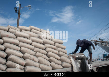 Gli uomini si muovono un sacco di cemento a Paotere Porto di Makassar, Indonesia. Foto Stock