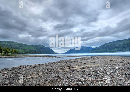 Mattina paesaggio norvegese con le montagne e la nebbia sul lago Foto Stock