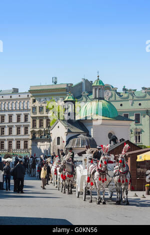 Carrozza di Cracovia, vista delle carrozze trainate da cavalli disponibili per i tour della città di Cracovia, in fila nella Piazza del mercato della città. Foto Stock