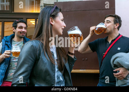 I turisti che bevono birra Pilsner Urquell fuori dal bar Lokal, via Misenska, Lesser Town, Praga, Repubblica Ceca, gustando le birre Foto Stock