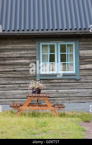 Vaso di fiori con margherite davanti casa in legno facciata. Foto Stock