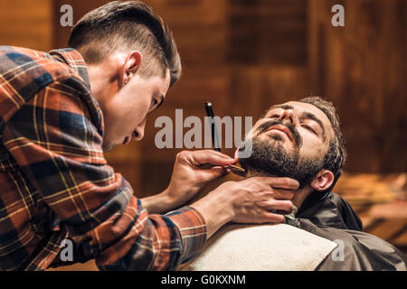 Un processo di rasatura di barbe in Barberia Foto Stock