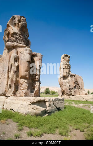 Doppia gigantesca statua del landmark faraone Amenhotep III denominato i Colossi di Memnon, Sculture pubbliche monumento a Luxor, Foto Stock