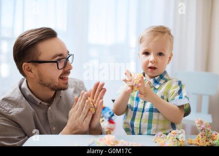 Padre e figlio giocare con argilla a sfera a casa Foto Stock