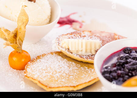 Gustose frittelle dolci con gelato alla vaniglia e topping Foto Stock