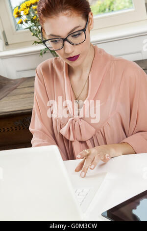 Giovane imprenditrice guardando seriamente di Computer Foto Stock