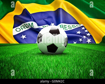 Pallone da calcio in erba e Bandiera Brasile Foto Stock