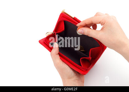 Mani femminili aggiungendo alcune monete nel portafoglio rosso Foto Stock