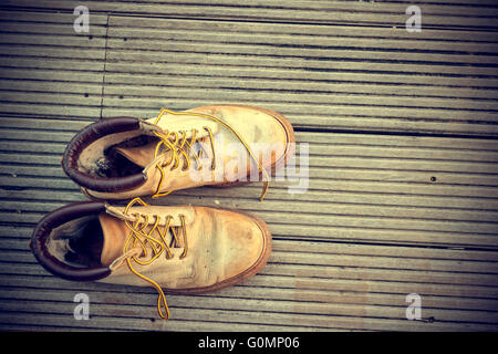 Close-up di Vintage vecchio paio stivali sul pavimento di legno Foto Stock