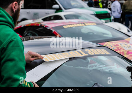 Dublino, Irlanda. 01 MAGGIO 2016 - un uomo si applica adesivi in vinile per una vettura alla partenza della Gumball 3000 gara di Budapest. Foto Stock